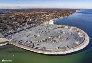 Drone-skud – Vedbæk Havn i vinterklæder med islagt havnebassin, bådebroer og Vedbæk i baggrunden